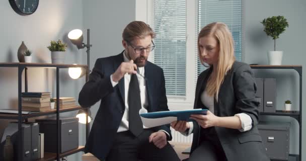 Два партнера держат документы и разговаривают в офисе — стоковое видео
