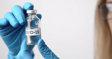 COVID 19 adlı test tüpünü tutan doktoru kapatın.