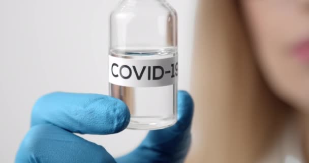 Primer plano del tubo de vidrio con el nombre de COVID 19 — Vídeos de Stock