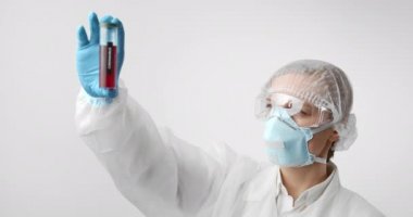 Kadın doktor COVID 19 üzerinde test için cam tüp tutuyor.
