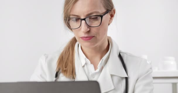 Mediziner tippt im Büro auf Laptop — Stockvideo