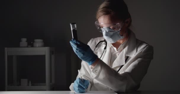 Медицинский работник осматривает пробирку с кровью — стоковое видео