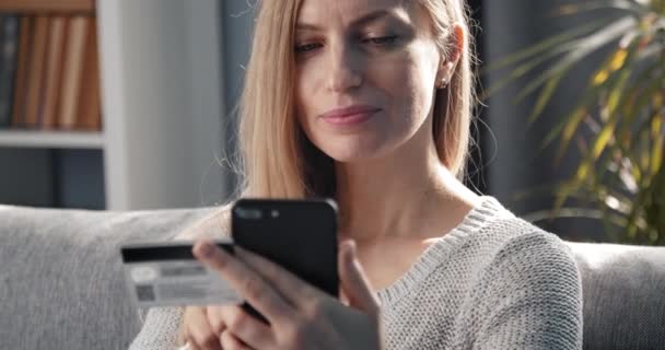 Volwassen vrouw met behulp van scredit card en smartphone voor winkelen — Stockvideo