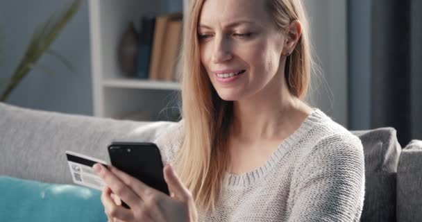 Усміхнена дама робить онлайн покупки на смартфоні — стокове відео