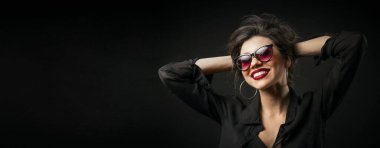 Kolları başının arkasında olan kadın.