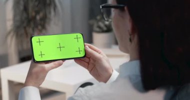 Krom tuşlu telefon ekranına tıklayan kadının arka planı