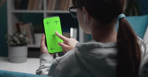Подросток трогает указательным пальцем зеленый экран смартфона — стоковое видео
