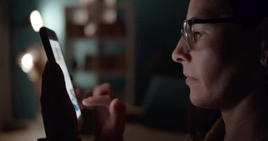 Sosyal ağları taramak için telefon kullanan kadının yan görünümü