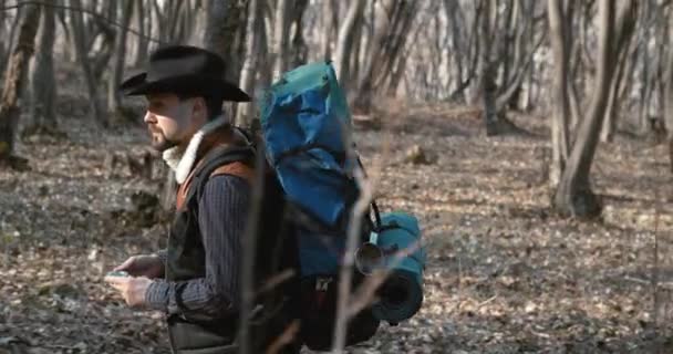Мужской турист, использующий компас в лесу — стоковое видео