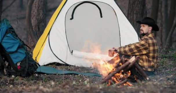 テントの近くで火を起こす男 — ストック動画