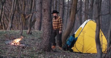 Kamptaki adam ateşin yanında dinleniyor.
