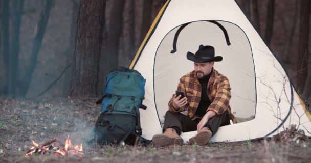 Männlicher Tourist benutzt Smartphone im Waldcamp — Stockvideo