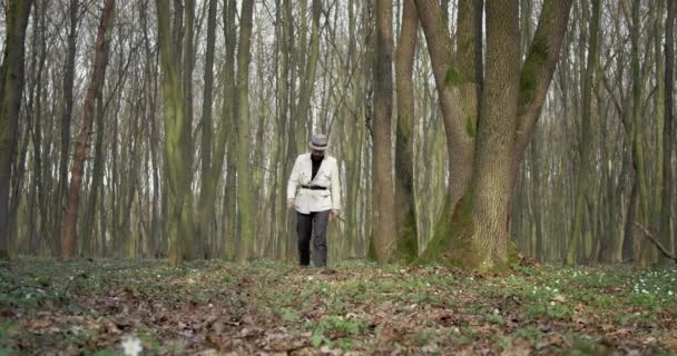Botanicus in hoed met wandelstok in het bos — Stockvideo