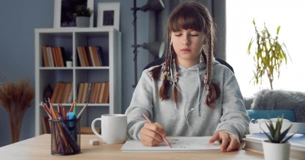 Portret dziewczynki siedzącej w domu i malującej — Wideo stockowe