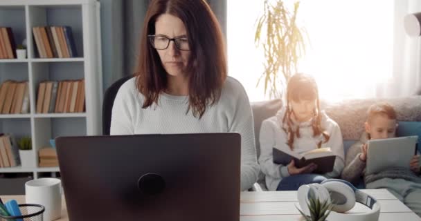 Mor som arbetar på distans och tar hand om barn i hemmet — Stockvideo