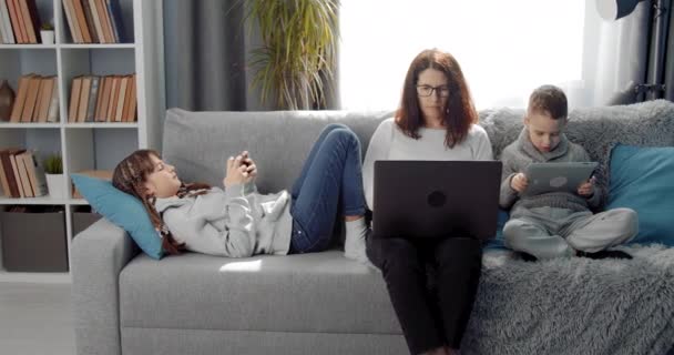 Glückliche Familie verbringt Zeit zu Hause mit persönlichen Gadgets — Stockvideo