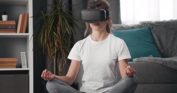 Jeune fille en lunettes virtuelles pratiquant le yoga — Video