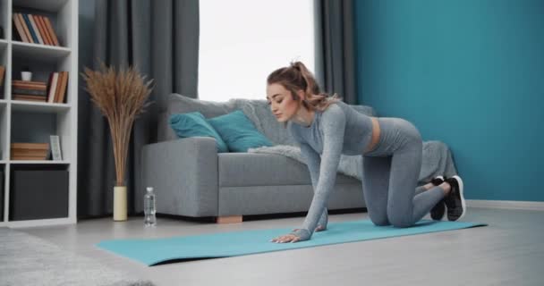 Ung flicka stående i planka på yogamatta hemma — Stockvideo