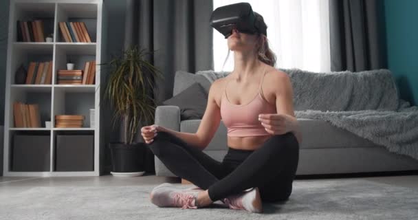 Mladá žena ve virtuálních brýlích relaxaci v póze lotos — Stock video
