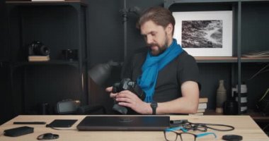 Sakallı fotoğrafçı dijital kameradan fotoğraf çekiyor.