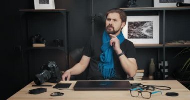 Fotoğrafçı stüdyoda fotoğrafları rötuşlamak için dizüstü bilgisayar kullanıyor.