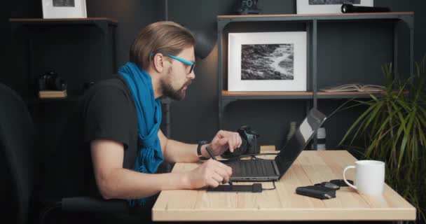 Fotograf bearbeitet Fotos auf Laptop im Studio — Stockvideo