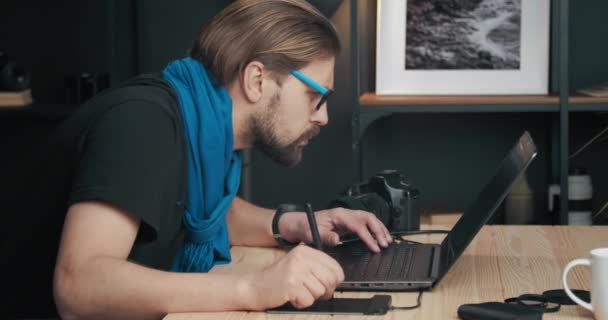 Poważny fotograf retuszowanie zdjęć na laptopie — Wideo stockowe