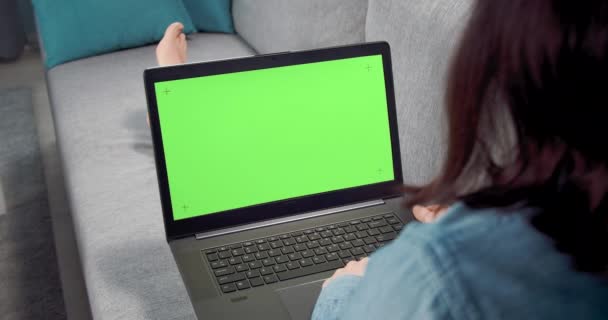 Gadis muda berbaring di sofa nyaman dengan laptop — Stok Video