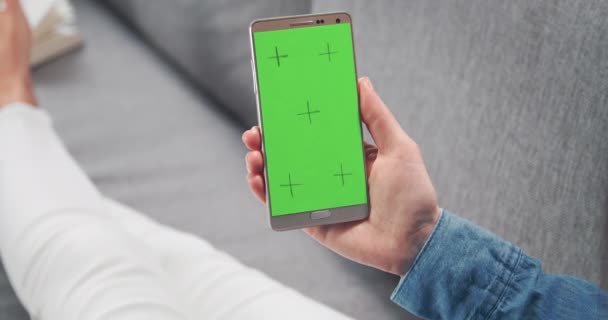 Vrouw liggend op de bank en met smartphone met leeg scherm — Stockvideo