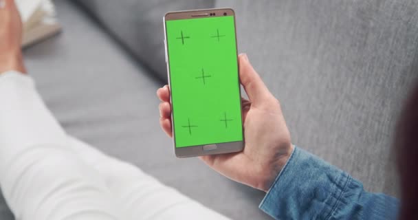 Vue arrière de la femme tenant le téléphone et glissant sur l'écran — Video