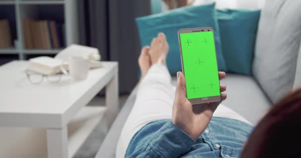 Vista desde atrás de la mujer deslizando hacia arriba en la pantalla en blanco del teléfono — Vídeos de Stock