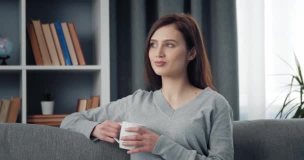 Πορτρέτο της γυναίκας χαλαρώνοντας στο σπίτι με φλιτζάνι καφέ — Αρχείο Βίντεο