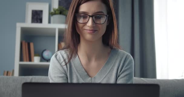Attraktives Mädchen benutzt Laptop bei der Arbeit zu Hause — Stockvideo