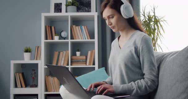 Charmant meisje met behulp van laptop voor op afstand werken thuis — Stockvideo