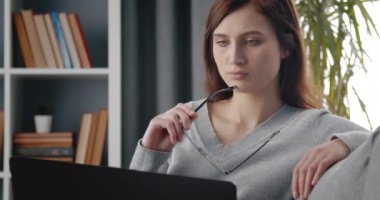 Evde otururken dizüstü bilgisayarda yazan güzel kız.