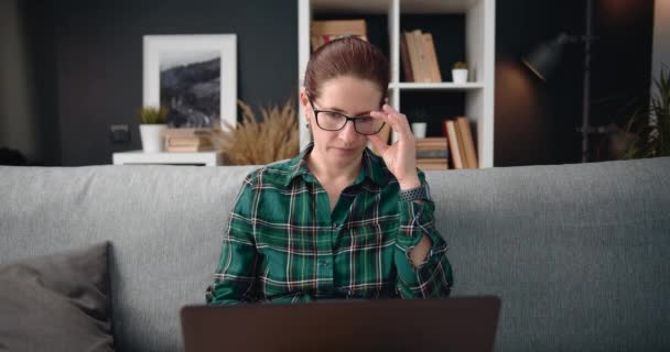 Gammal kvinna känner sig trött efter arbetsdag på laptop — Stockvideo