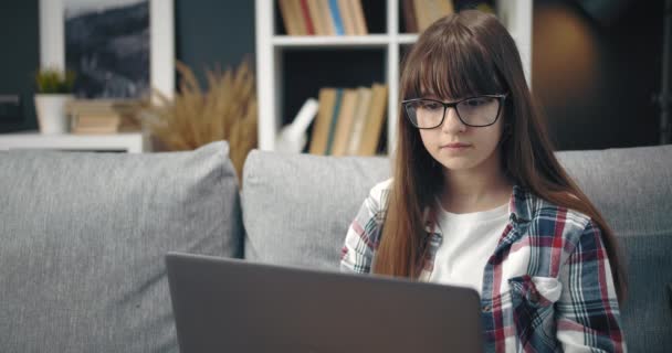 Pretty girl in glasses studying online at home — Stock Video