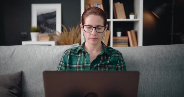 Ώριμη γυναίκα που χρησιμοποιεί υπολογιστή για βιντεοκλήση στο σπίτι — Αρχείο Βίντεο