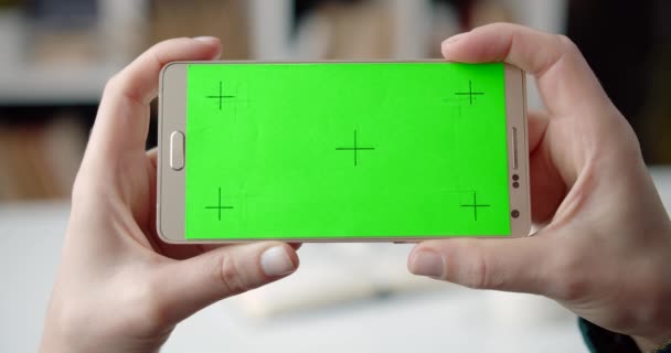 Vrouw in de hand smartphone met groen scherm — Stockvideo