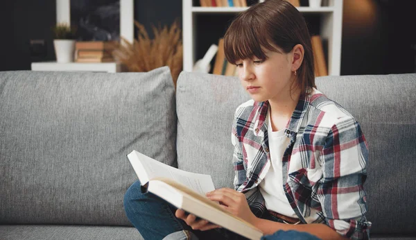 Livre de lecture adolescent sur canapé — Photo