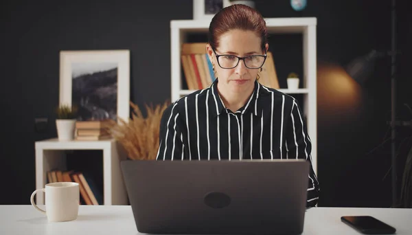 Mujer seria trabajando desde casa — Foto de Stock