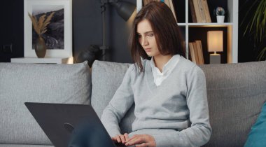 Dizüstü bilgisayarlı koltukta oturan bayan.