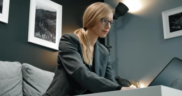 ソファに座っている間にラップトップで働くビジネス女性 — ストック動画