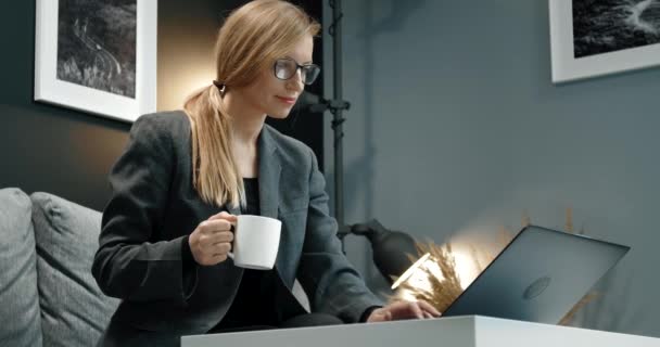 快乐的女人一边喝咖啡一边在电脑上工作 — 图库视频影像