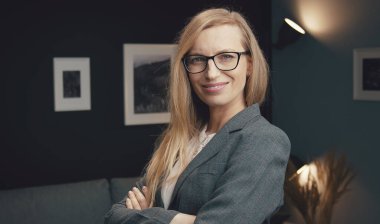 Kollarını kavuşturmuş gülümseyen bir iş kadını.