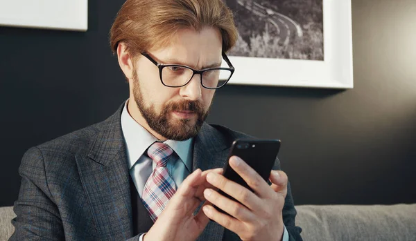 Konzentrierter Geschäftsmann blickt auf Smartphone-Bildschirm — Stockfoto