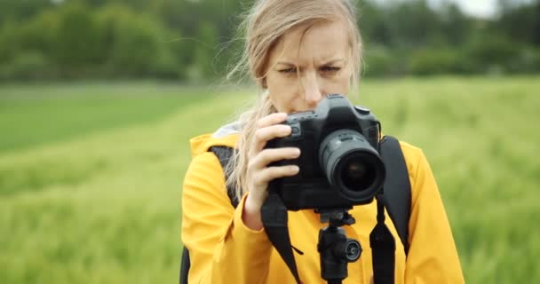 Woman making setting on camera before shooting nature — Stock Video