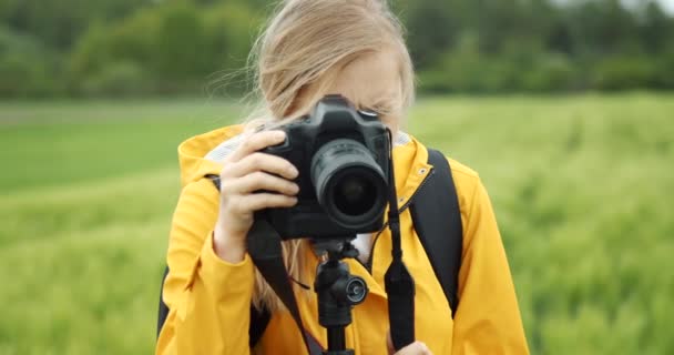 자연 사진을 찍고 삼각대를 사용하는 매력적 인 여성 — 비디오