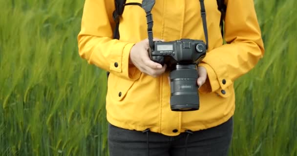Woman reviewing taken pictures on digital camera outdoors — Stock Video