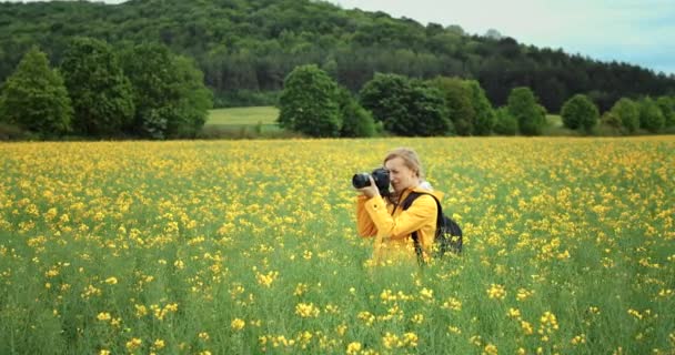 Glad fotograf skjutfält med gula blommor — Stockvideo